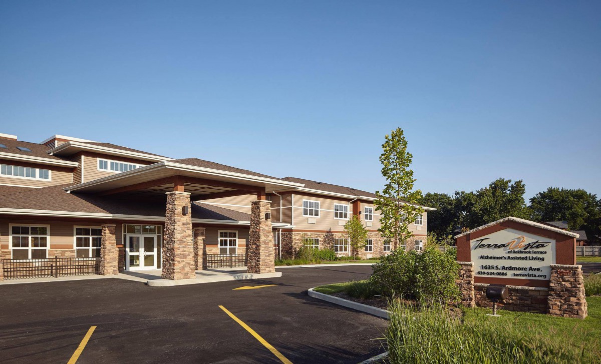A modern building with a landscaped entrance and clear blue sky.