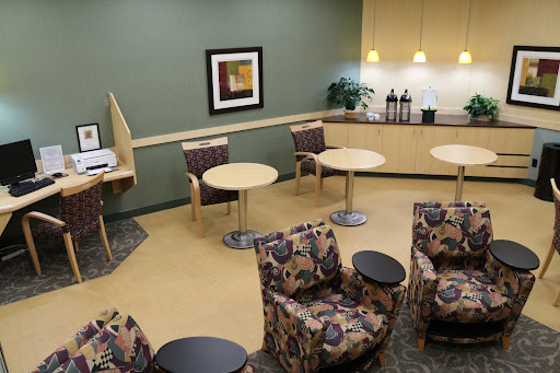 A cozy waiting area featuring comfortable seating and a coffee station.
