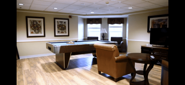 A cozy game room with a pool table and comfortable seating.