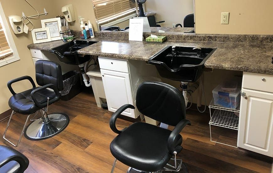 A hair salon setup featuring barber chairs, sinks, and workstations.