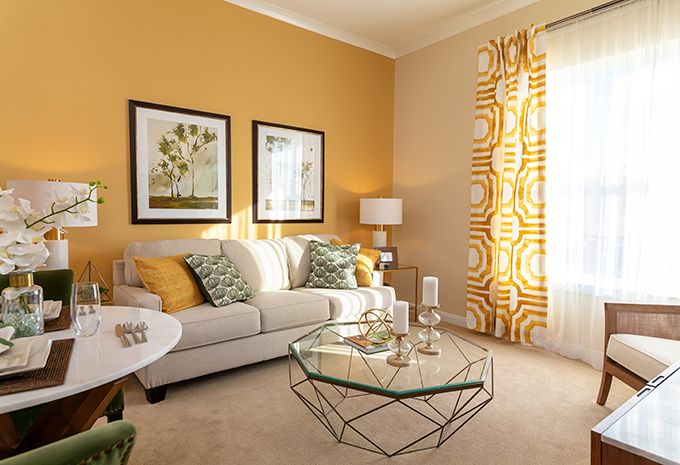 A modern living room with yellow walls and stylish decor.