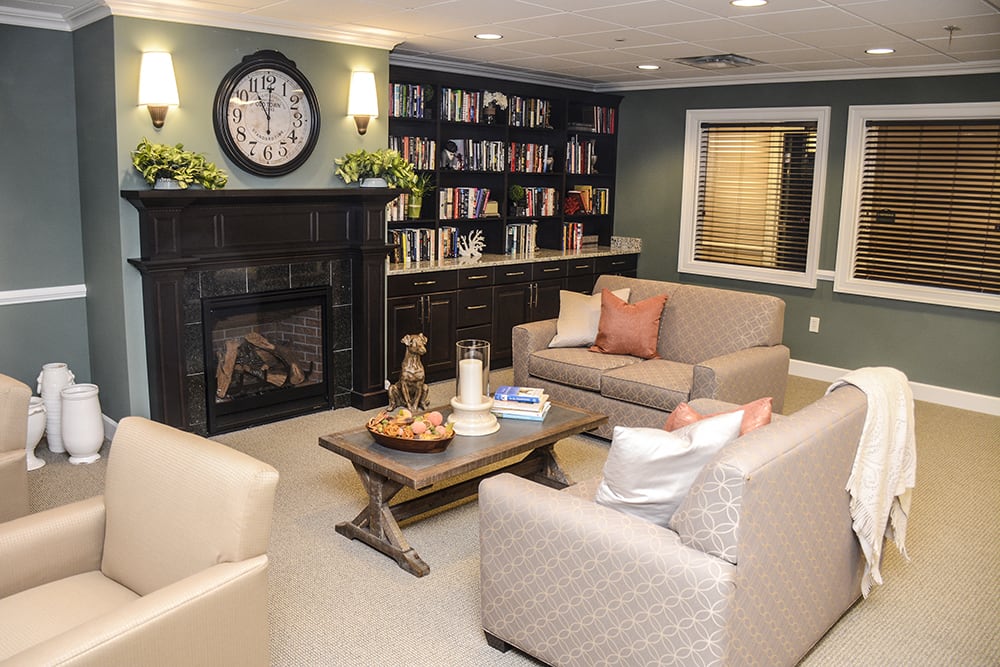 Cozy living room with a fireplace, bookshelves, and comfortable seating.