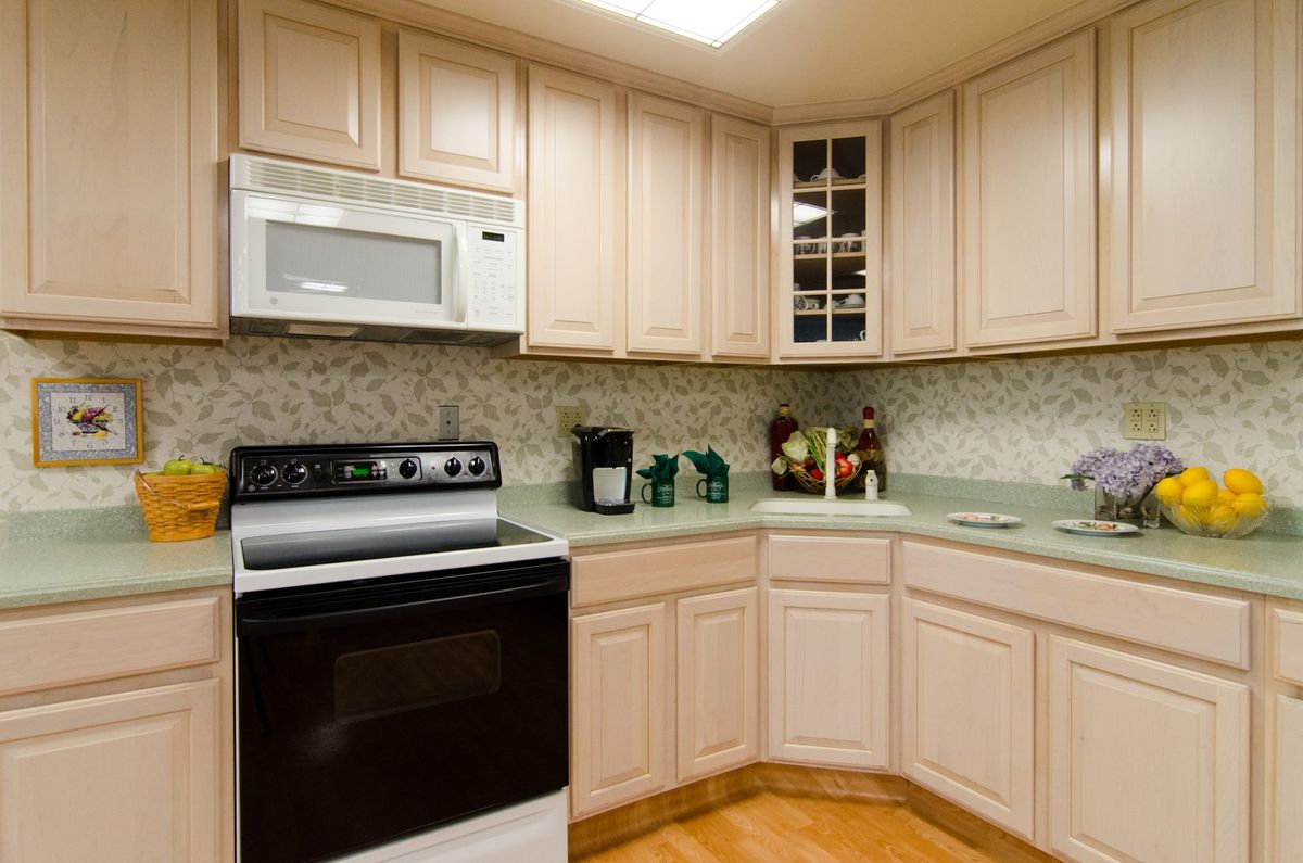 Modern kitchen with light-colored cabinets and appliances.