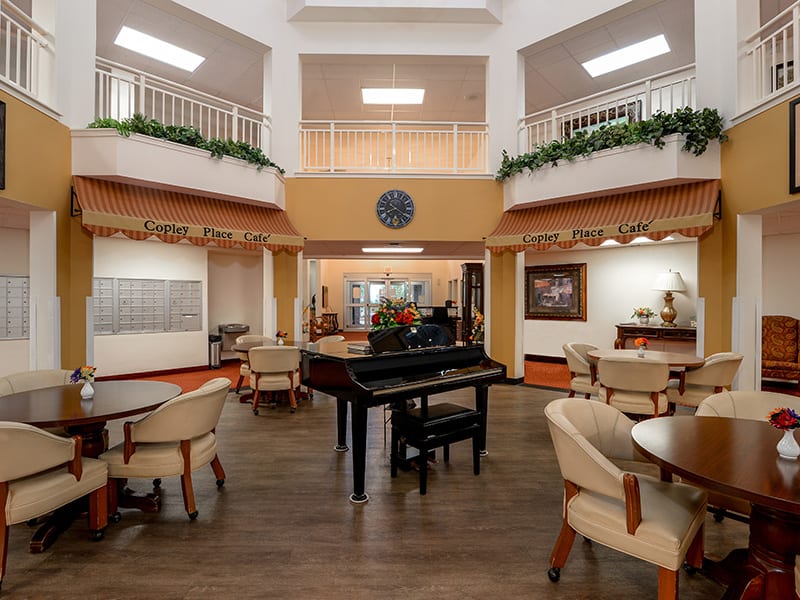 A spacious lobby area featuring a grand piano and comfortable seating arrangements.