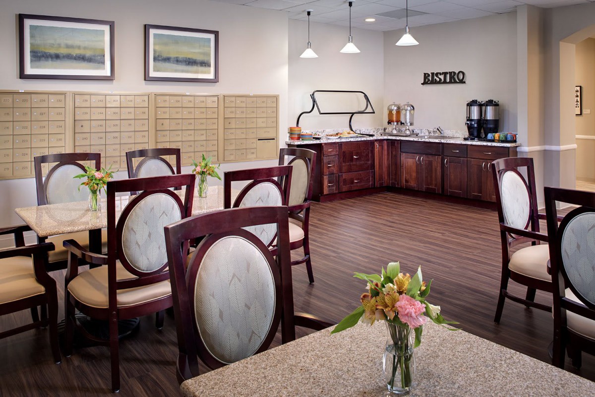 A cozy dining area with elegant seating and a kitchenette in the background.