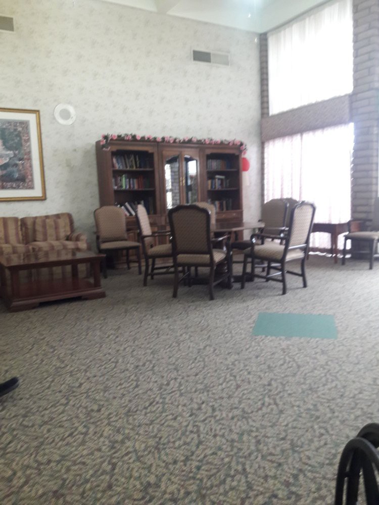 A cozy library interior with chairs and bookshelves.