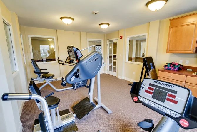 A small gym room with various exercise machines and equipment.