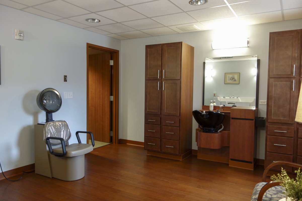 A salon interior with a hair drying station and mirror.