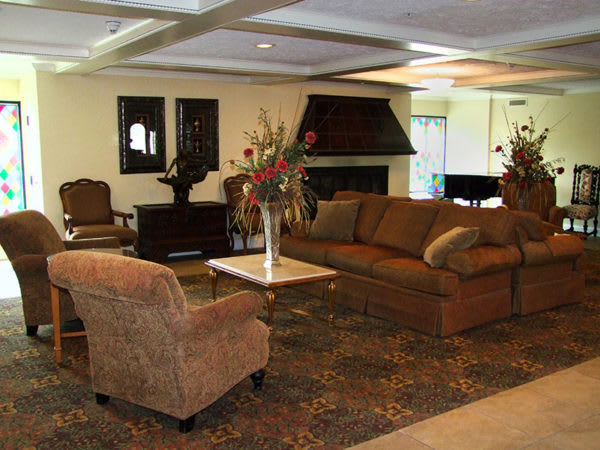 A comfortable living room with sofas, armchairs, and a coffee table, featuring elegant decor and warm lighting.