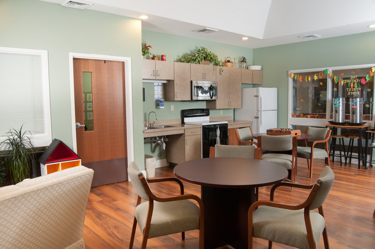 A modern kitchen and dining area featuring wooden flooring, stylish furniture, and contemporary appliances.