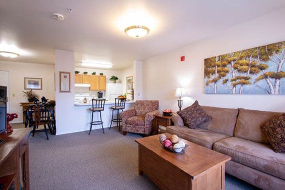 Cozy living space with a sofa and coffee table, leading into an open-plan kitchen.
