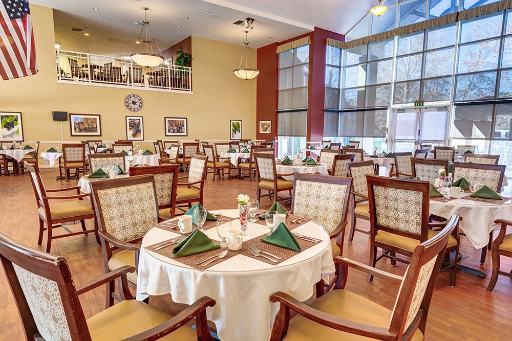 An elegant dining room with neatly arranged tables and chairs, featuring a warm and inviting atmosphere.