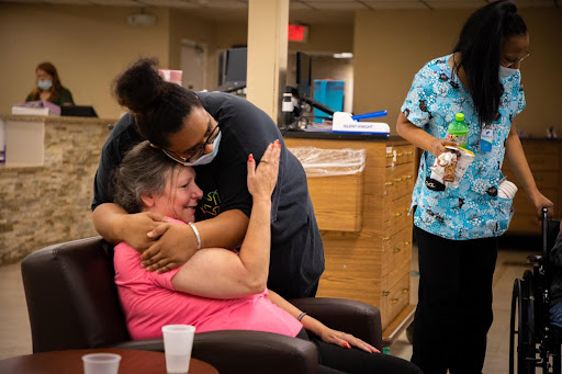 A heartfelt moment of care and connection between a caregiver and an elderly resident, highlighting the importance of emotional support in healthcare.