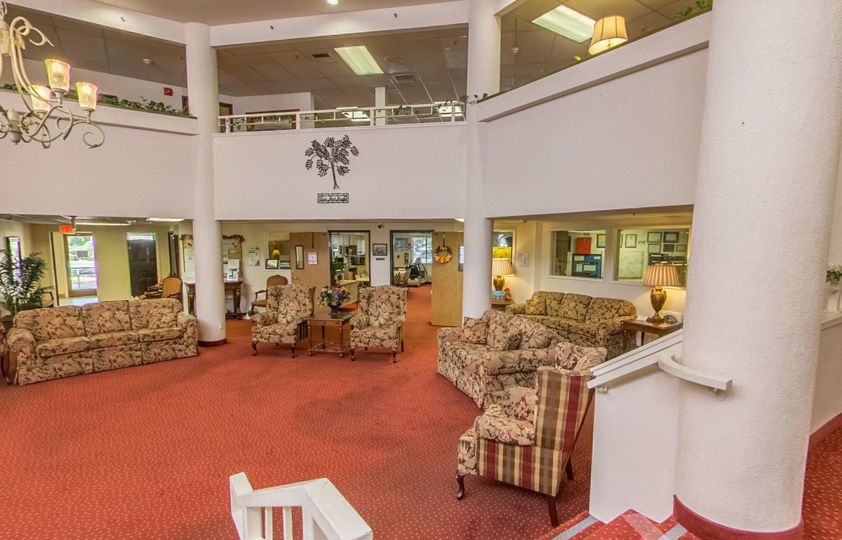 A spacious lobby with comfortable seating, featuring sofas, armchairs, and a warm carpet.