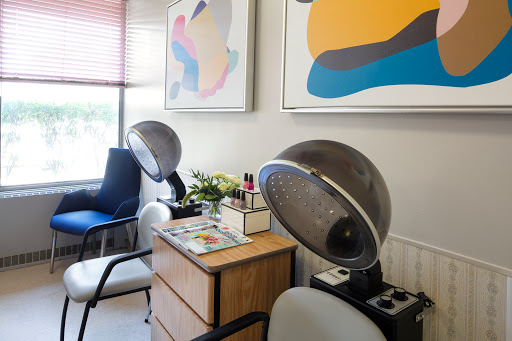 A cozy hair salon featuring vintage hair dryers and modern artwork.
