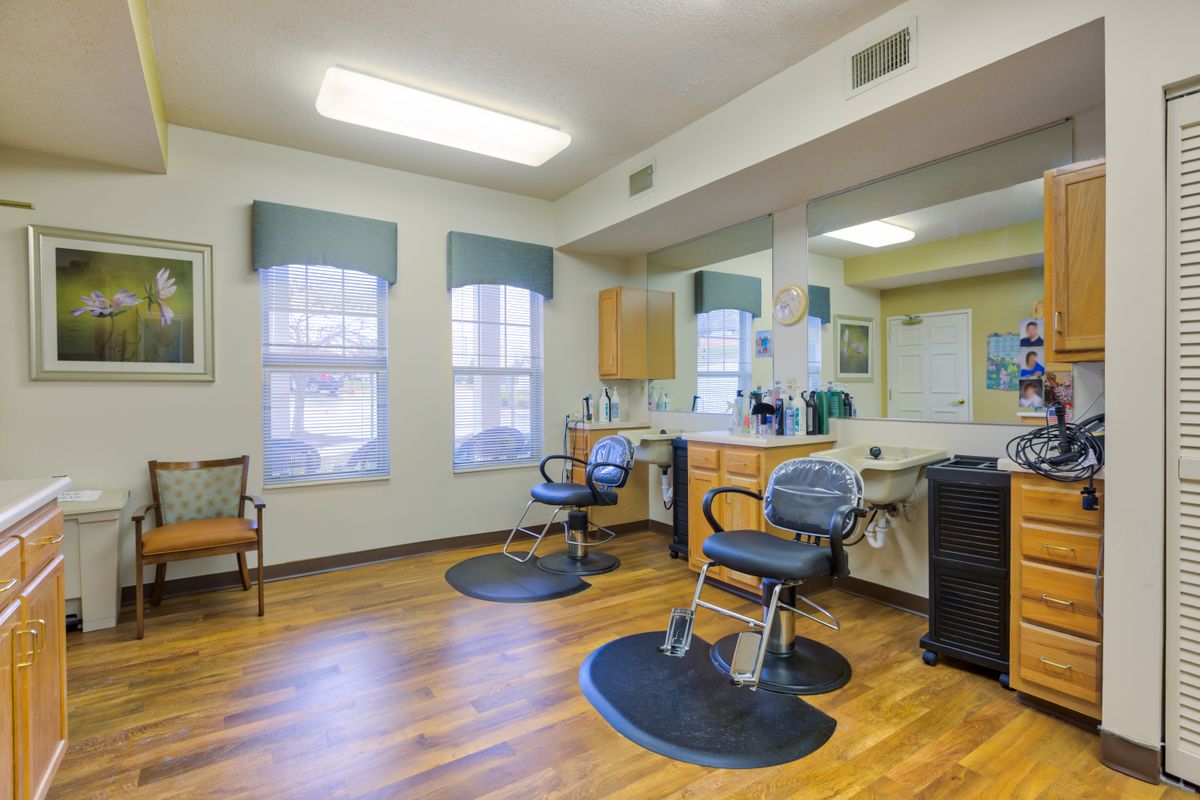 An inviting hair salon interior with comfortable chairs and large mirrors.