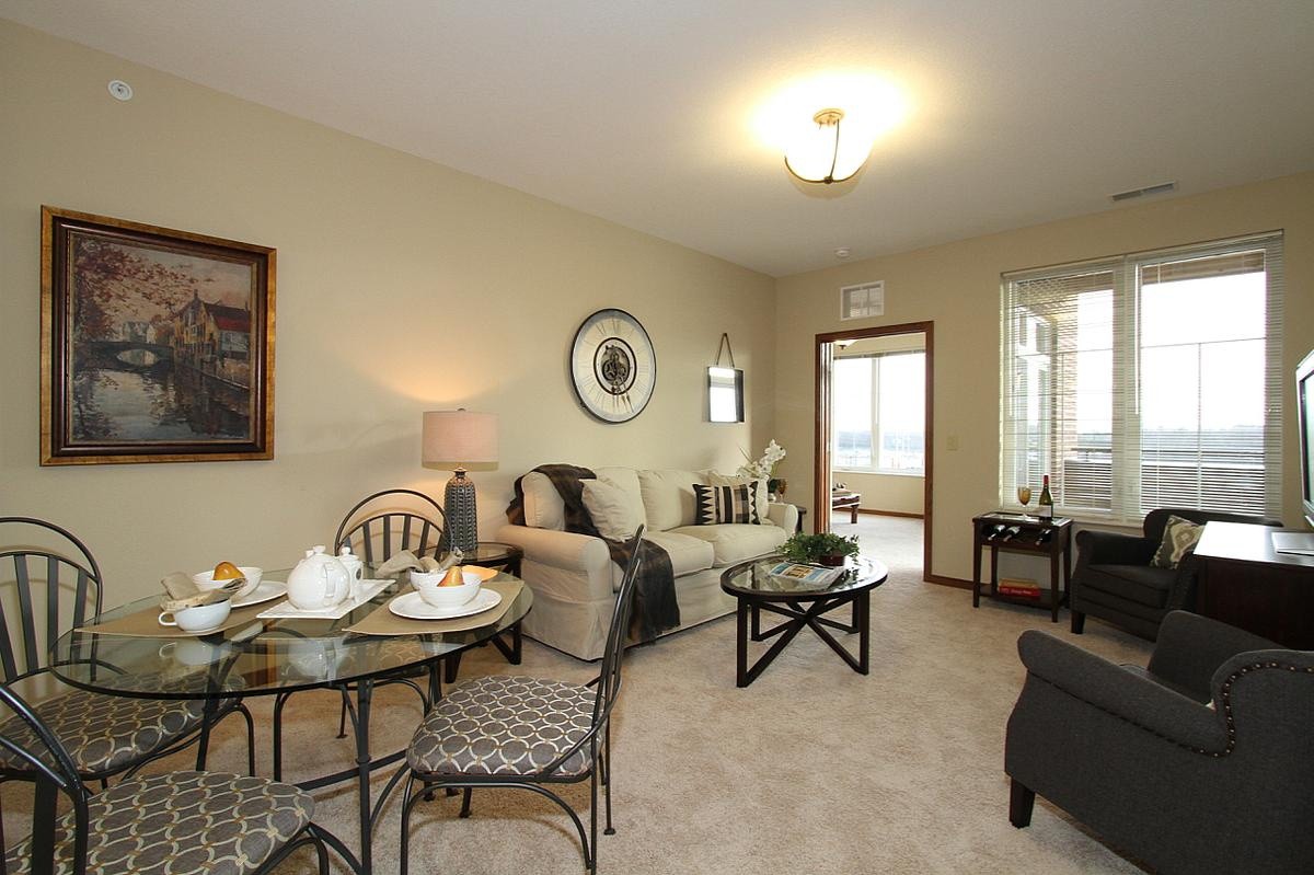 A cozy living room with an adjoining dining area, featuring comfortable seating and elegant decor.