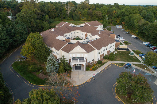 Aerial view of a uniquely designed residential building surrounded by lush greenery.