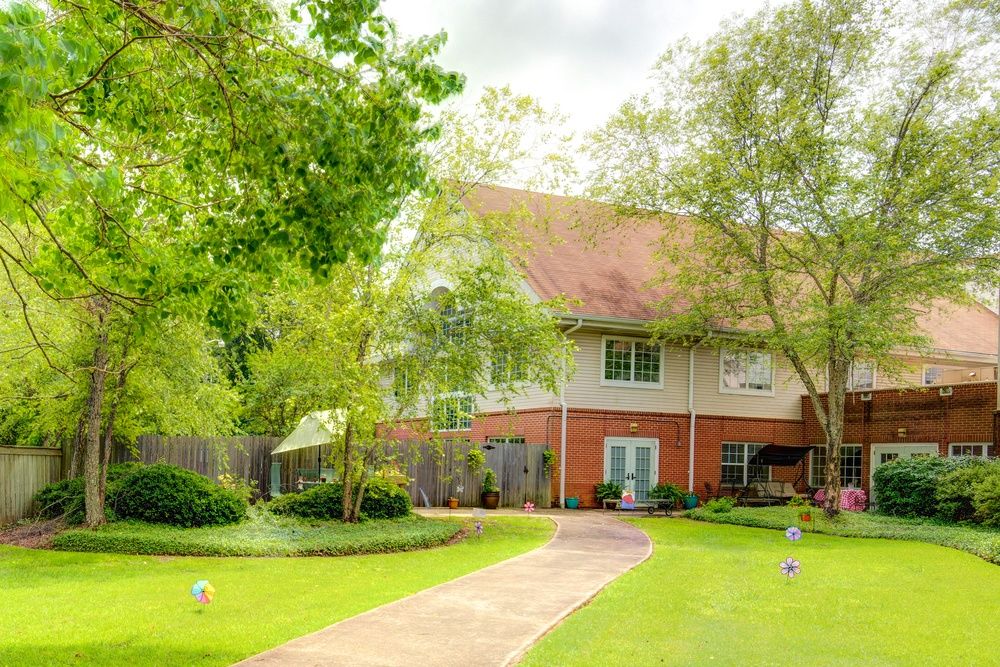 A serene house surrounded by lush greenery and a well-maintained garden.