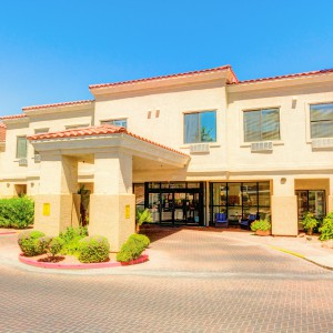 A sunny daytime view of a hotel building entrance.