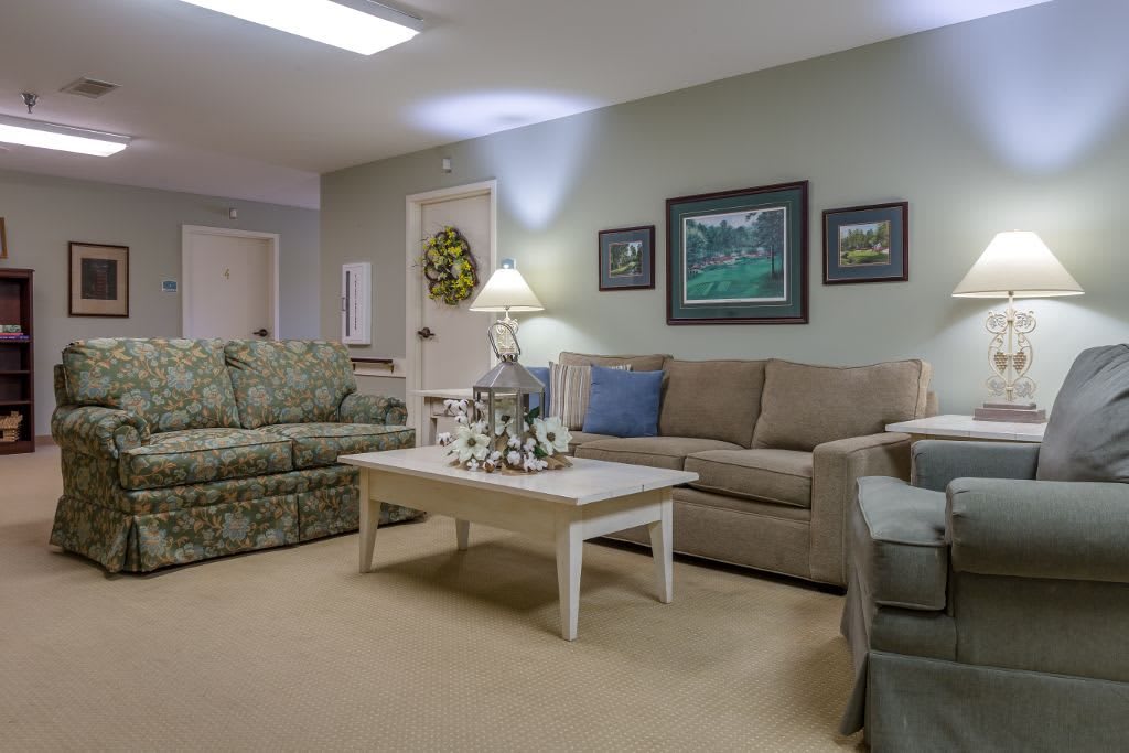 A cozy living room with comfortable sofas, a coffee table, and decorative wall art.