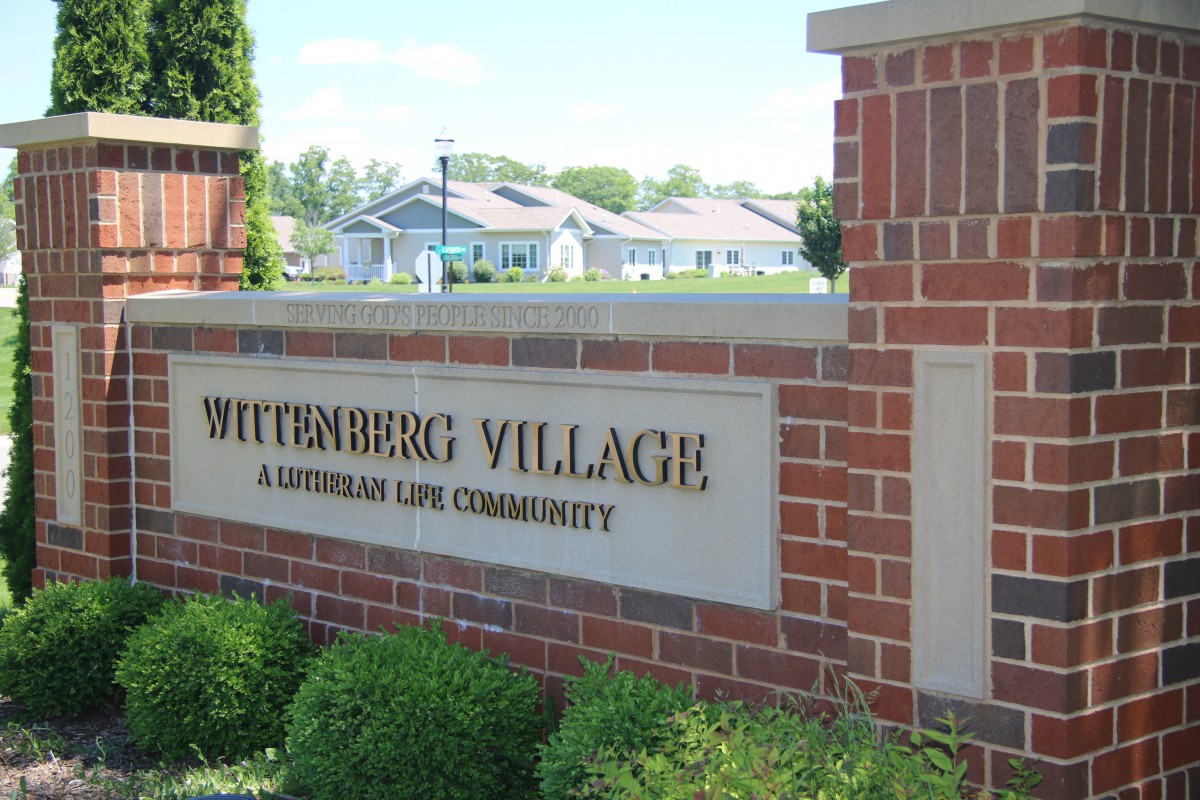 Entrance sign for Wittenberg Village, a Lutheran Life Community, set in a landscaped area.