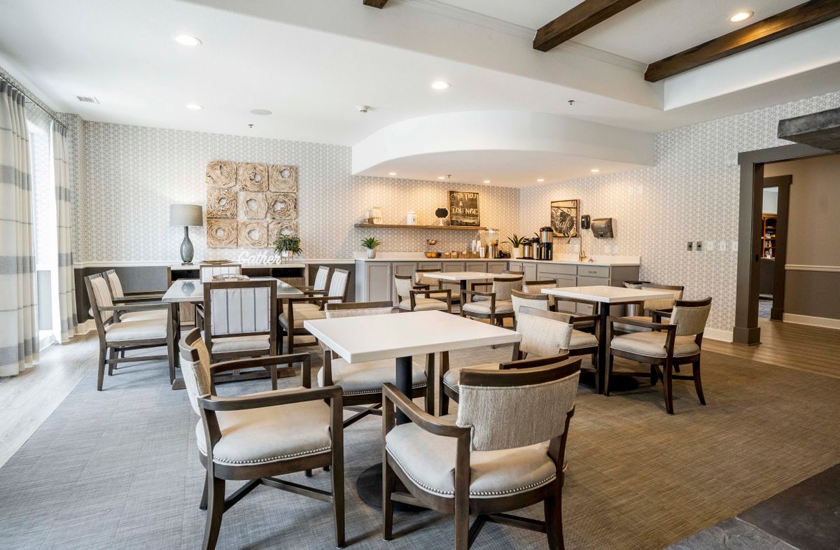 A modern dining area with cozy seating and a small kitchen setup.