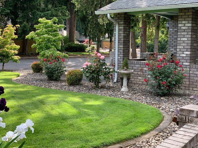 A beautifully landscaped garden featuring a gazebo, lush green grass, and vibrant flowers.