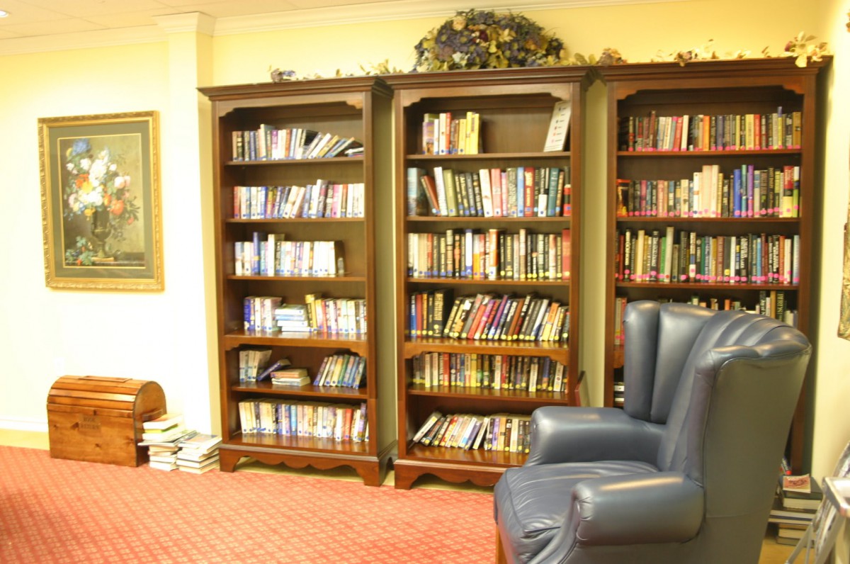 A cozy library corner with bookshelves filled with books and a comfortable leather chair.