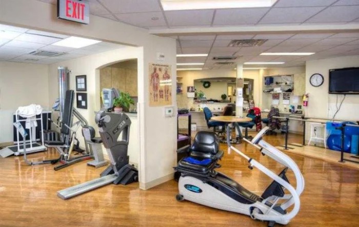 A fitness center with a variety of exercise equipment including treadmills and stationary bikes.