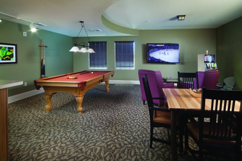 A cozy game room featuring a pool table, television, and comfortable seating.