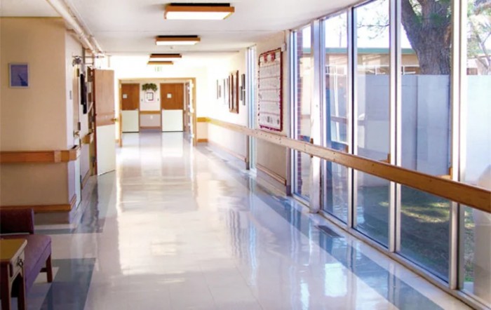 A bright and clean hospital corridor with large windows.