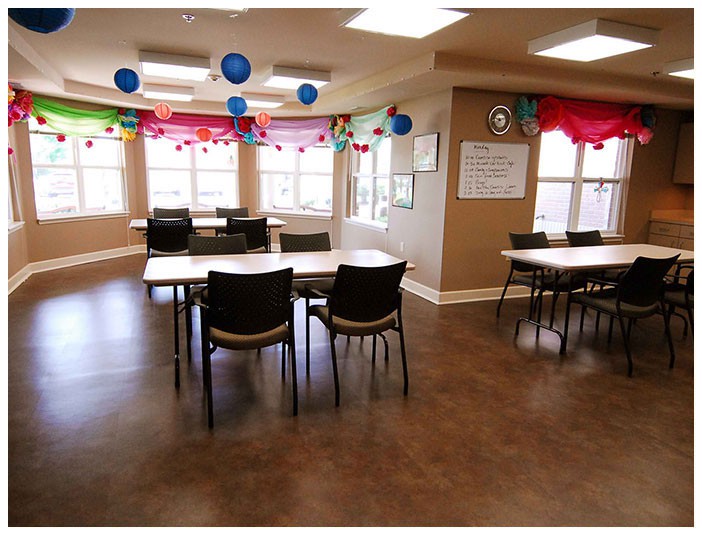 A decorated classroom with tables and chairs set up for an event.
