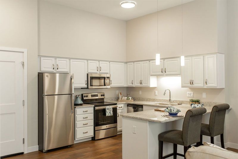 Modern kitchen with stainless steel appliances and white cabinetry.