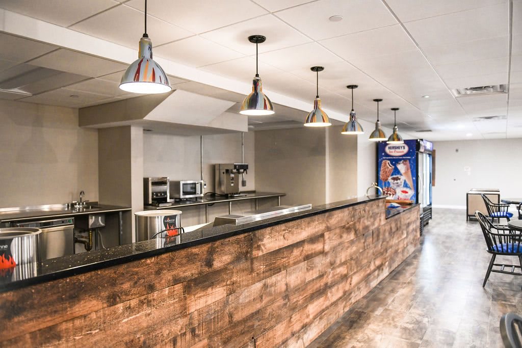 A modern kitchen with wood paneling and industrial-style lighting.