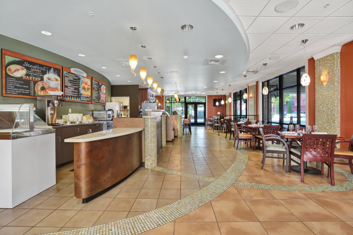 A spacious cafe interior with a counter and seating area.