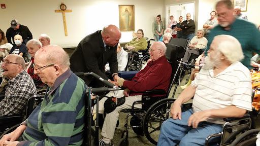 A heartwarming moment of connection between a visitor and a resident at a care facility.