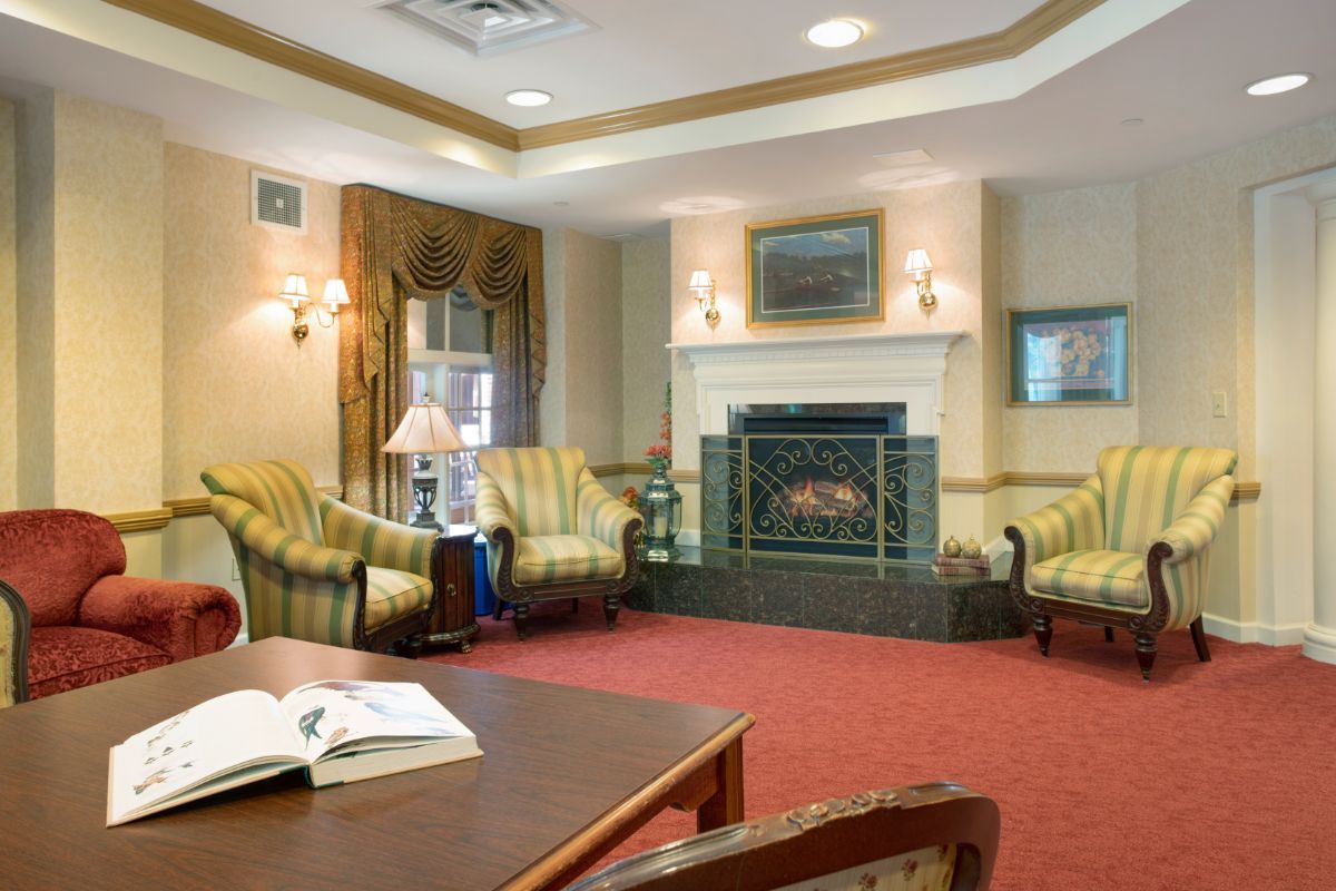 A cozy living room with traditional decor, featuring a fireplace and comfortable seating.