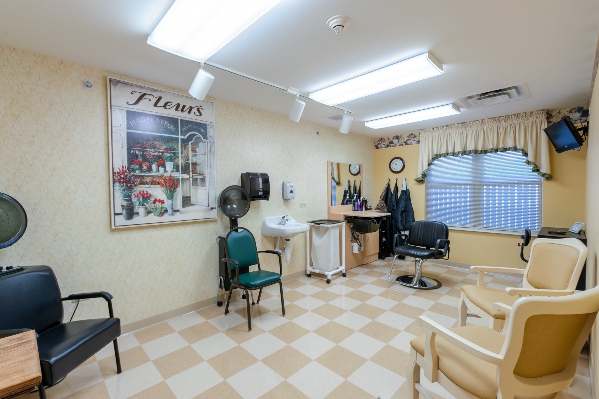 An interior view of a hair salon with chairs, a workstation, and equipment.