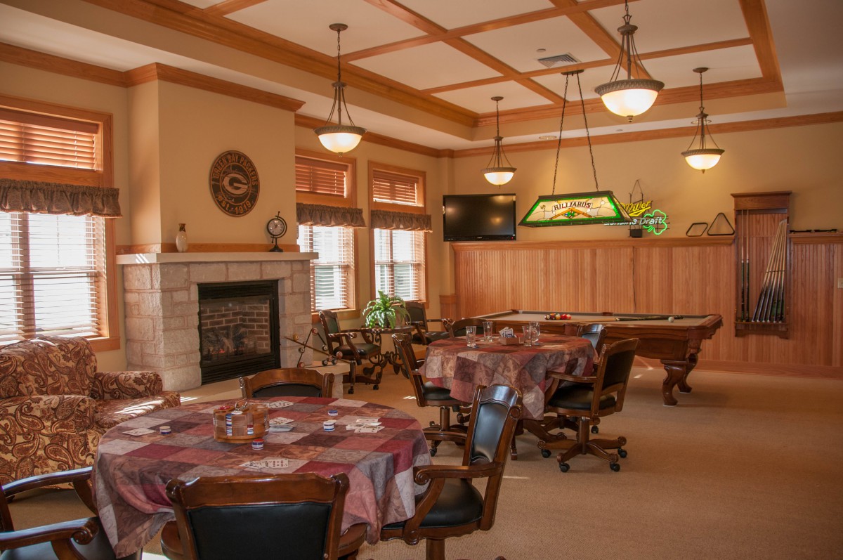 A cozy dining room with multiple tables, a fireplace, and a pool table.