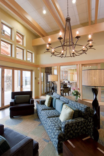 A beautifully designed living room featuring modern decor, ample natural light, and an elegant chandelier.