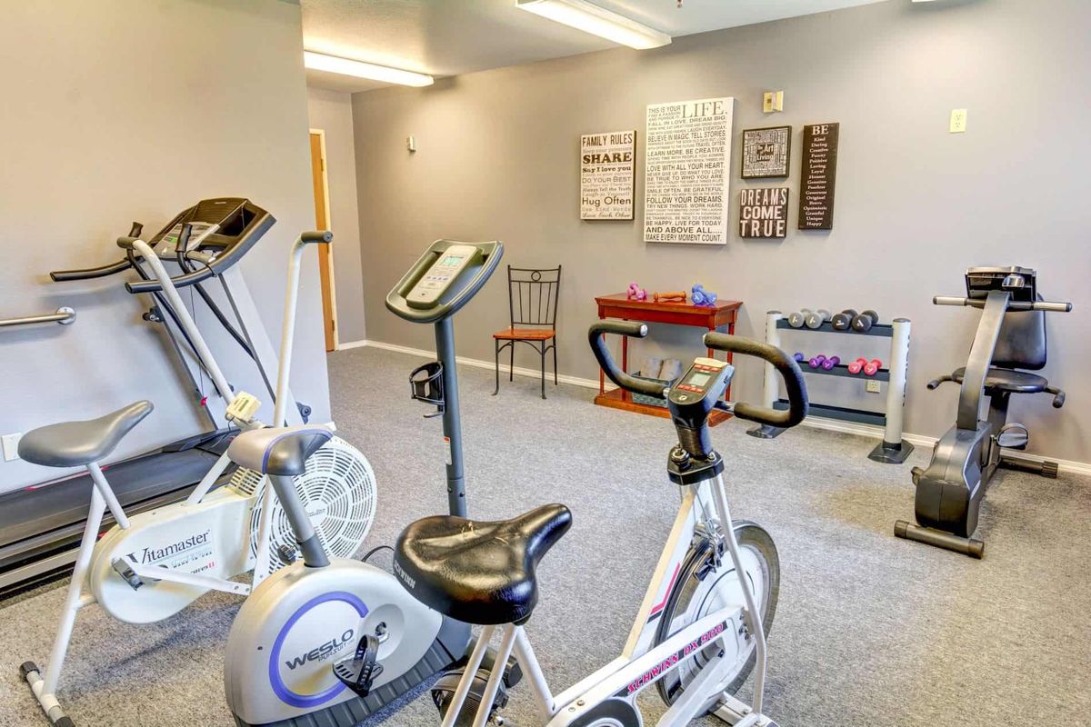 A small gym room featuring stationary exercise bikes and fitness equipment.