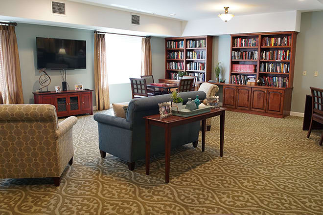 A cozy living room with bookshelves and comfortable seating.