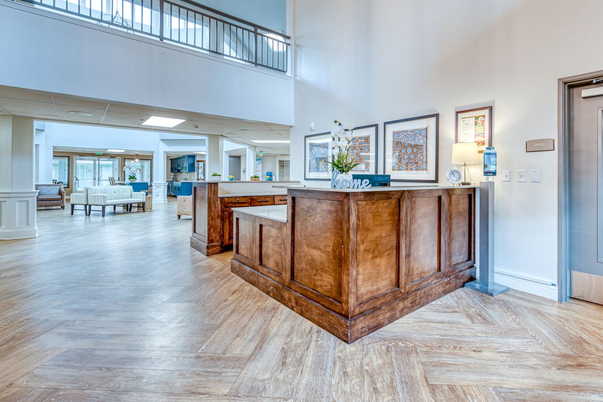 A modern lobby with a wooden reception desk and bright lighting.