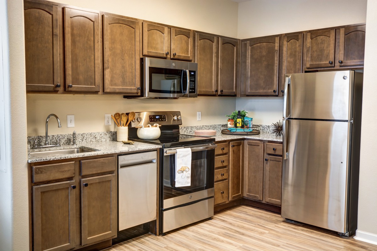 A modern kitchen featuring wooden cabinets and stainless steel appliances.
