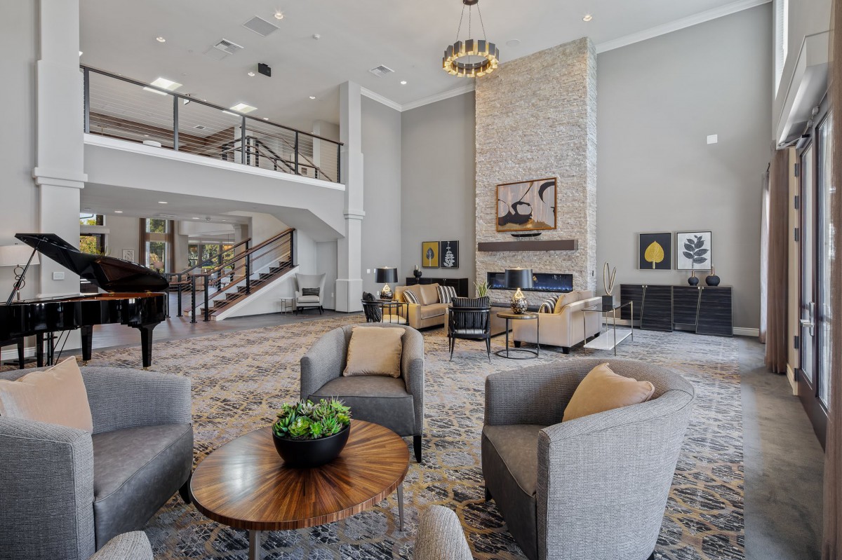 A modern and cozy lobby with a fireplace, featuring stylish furniture arranged in a comfortable seating area.
