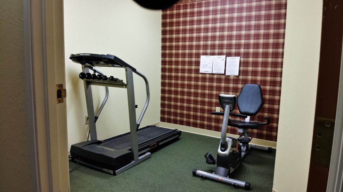 A small fitness room with a treadmill and an exercise bike.