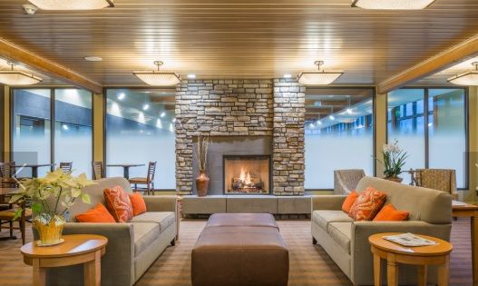 A cozy living room with a modern stone fireplace and comfortable seating.