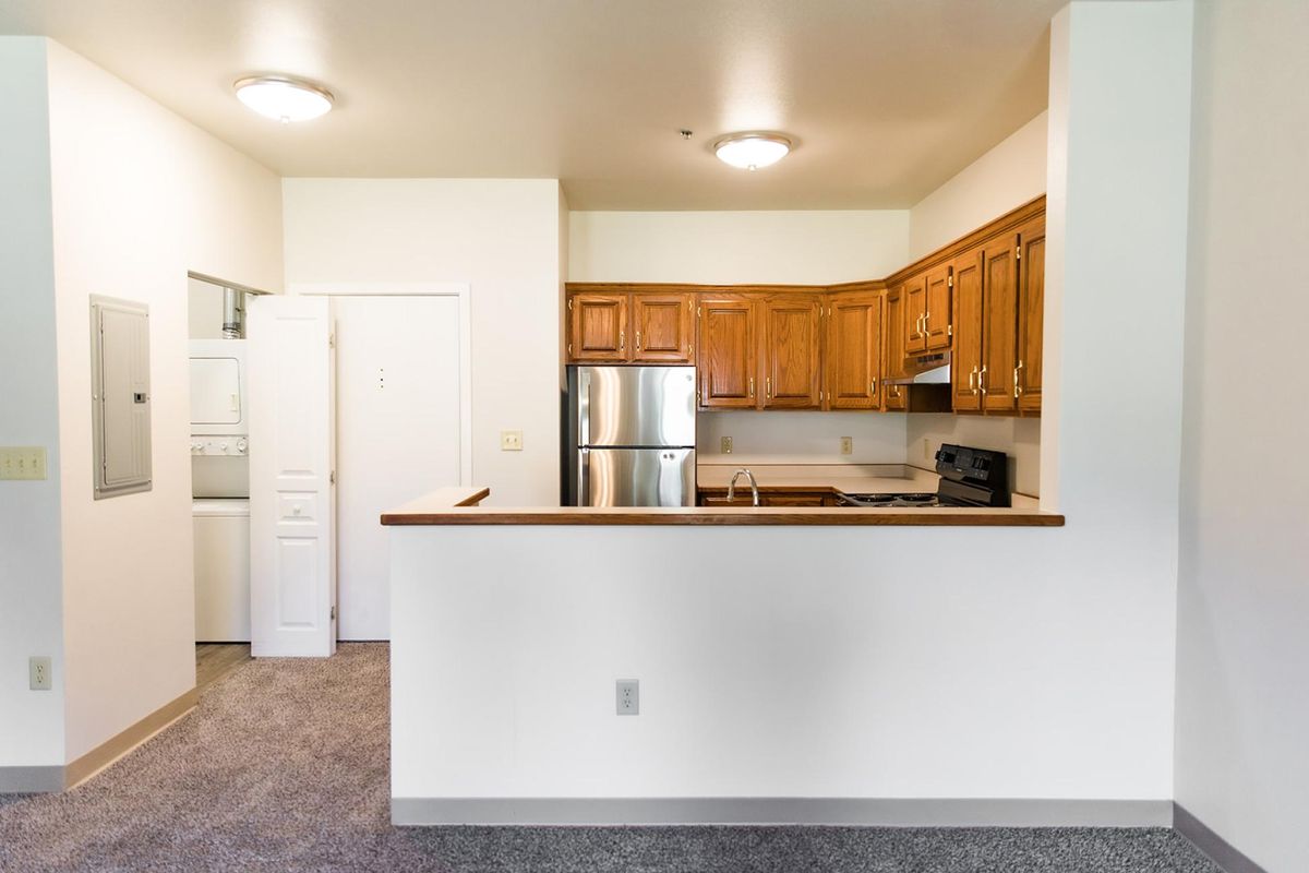 A modern kitchen with wooden cabinets and stainless steel appliances.