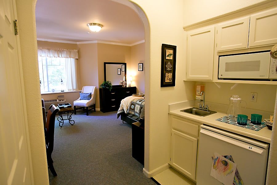 A cozy studio apartment with a bedroom and kitchenette.